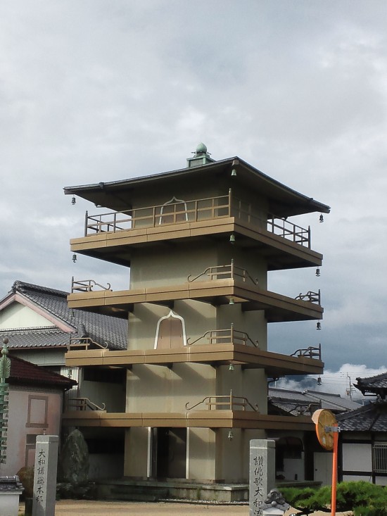 金倉寺を北に出て　　国道と交わるすぐ手前の　鉄筋５重塔　　これを撮ってる　背中側にうどんの有名店あり