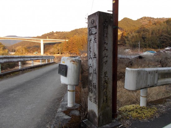 遍路道にある道標。右「ほんみみず」、左「そえみみず」と書かれている。遠くに見える橋梁は、国道56号線である。